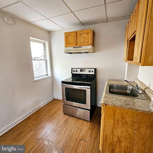 kitchen featuring a drop ceiling, stainless steel electric range oven, sink, and light hardwood / wood-style flooring