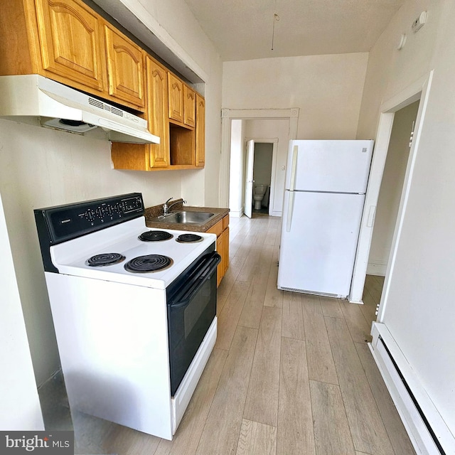 kitchen with sink, white appliances, baseboard heating, and light hardwood / wood-style flooring