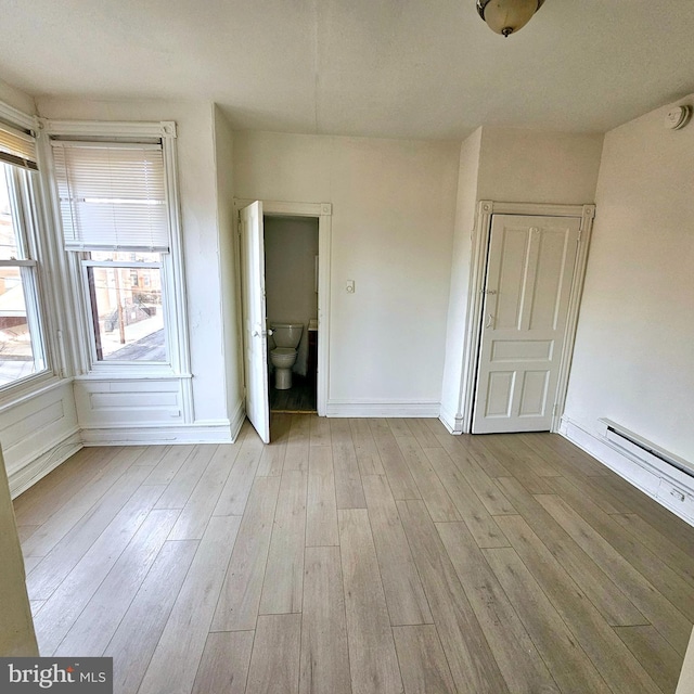 empty room featuring light hardwood / wood-style flooring and baseboard heating