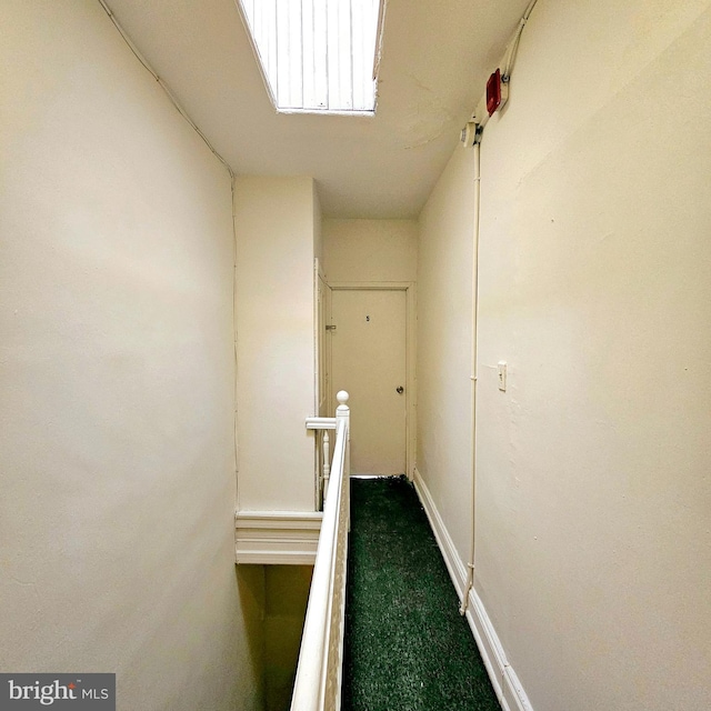 hall featuring dark colored carpet