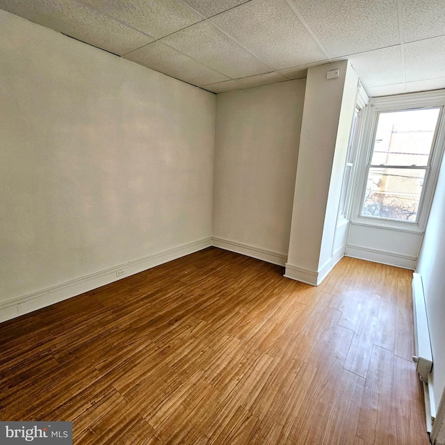 spare room featuring hardwood / wood-style floors and a paneled ceiling