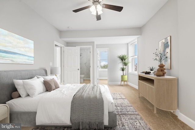 carpeted bedroom with ensuite bathroom and ceiling fan