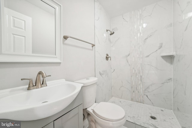 bathroom featuring tiled shower, vanity, and toilet