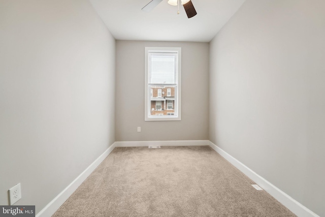 carpeted spare room featuring ceiling fan