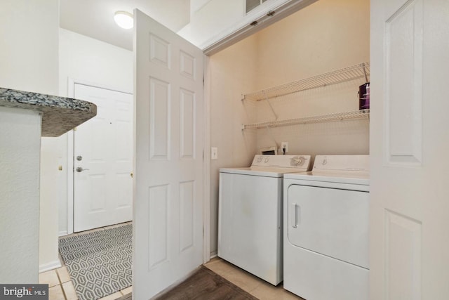 laundry room featuring light tile patterned flooring and washing machine and clothes dryer