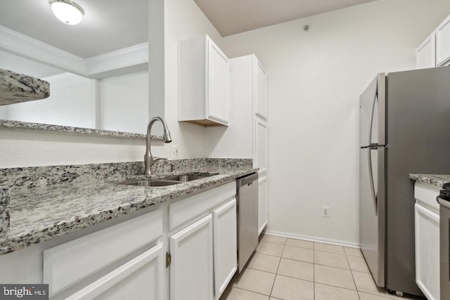 kitchen featuring sink, light tile patterned floors, appliances with stainless steel finishes, ornamental molding, and white cabinets