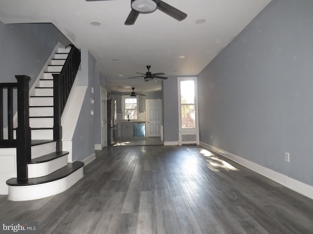 unfurnished living room featuring dark hardwood / wood-style flooring and ceiling fan