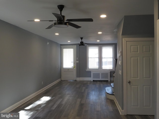 interior space with dark hardwood / wood-style flooring, ceiling fan, and radiator heating unit