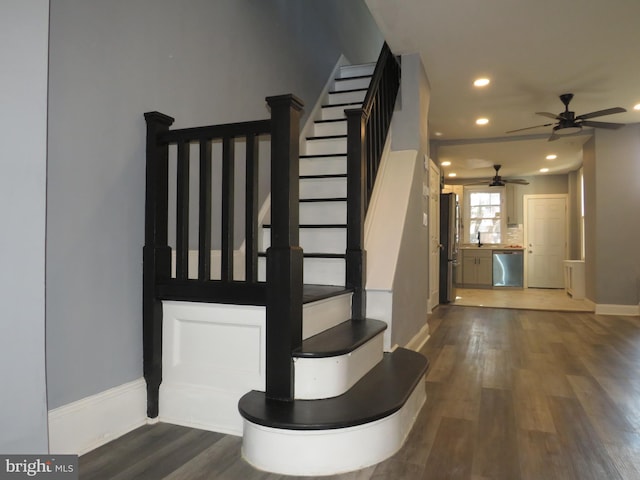 stairs featuring hardwood / wood-style floors and ceiling fan