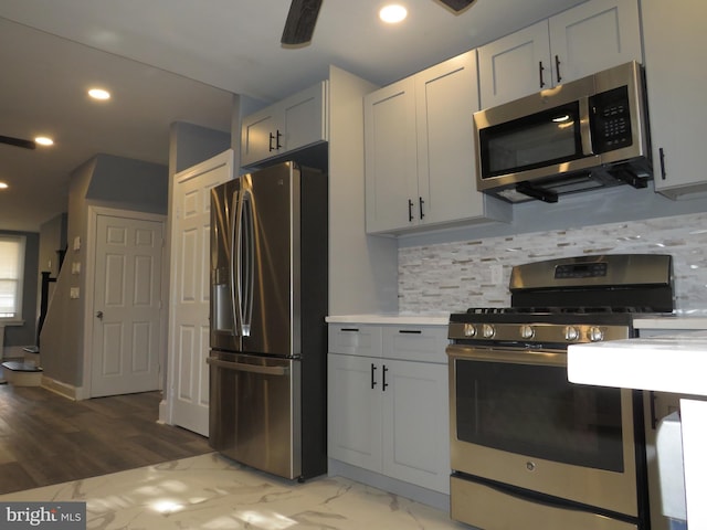 kitchen with decorative backsplash, appliances with stainless steel finishes, and white cabinetry