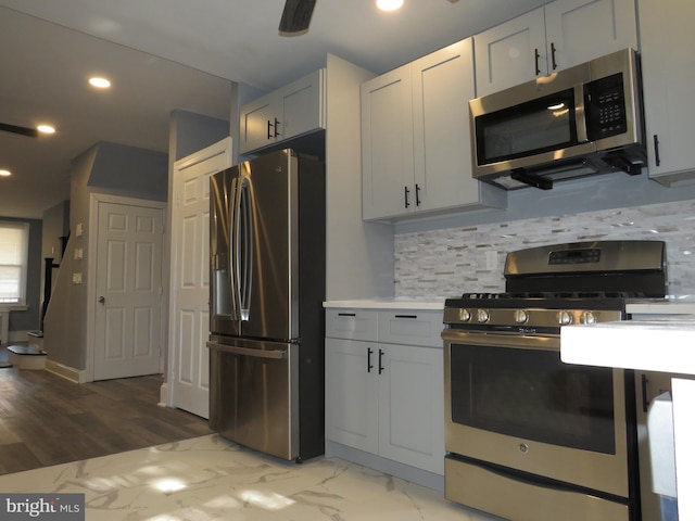 kitchen with appliances with stainless steel finishes, tasteful backsplash, and white cabinetry