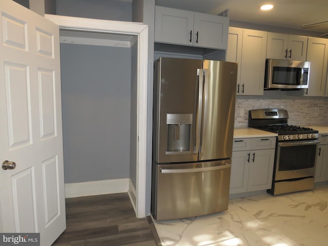 kitchen featuring decorative backsplash, gray cabinets, and appliances with stainless steel finishes