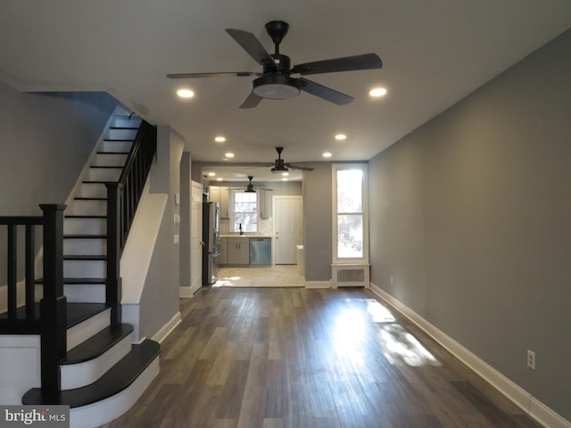 unfurnished living room featuring ceiling fan and dark hardwood / wood-style flooring