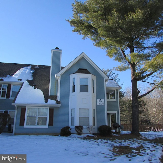 view of front of home featuring a chimney and fence