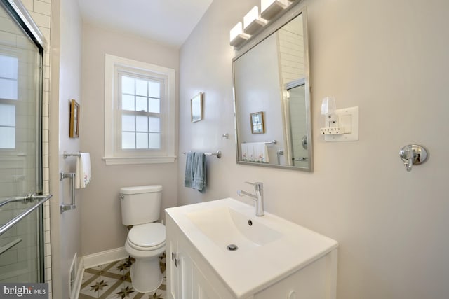 bathroom with toilet, an enclosed shower, and vanity