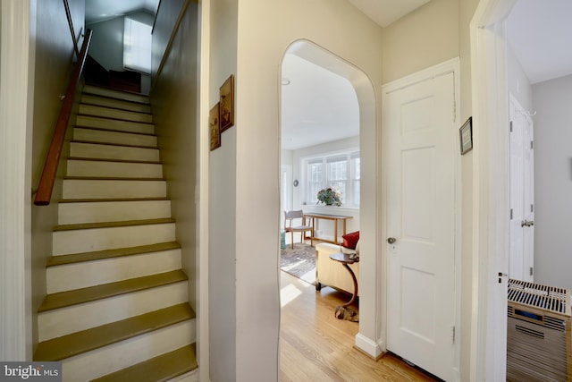 stairway featuring heating unit and hardwood / wood-style flooring