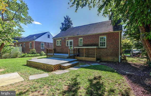 back of property featuring a deck and a lawn