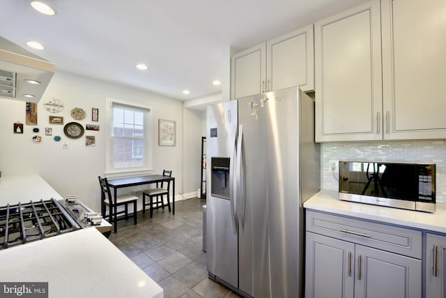 kitchen featuring stainless steel appliances and tasteful backsplash