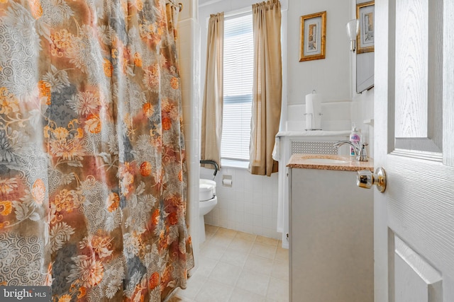 bathroom with toilet, tile walls, vanity, and curtained shower