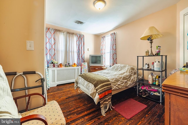 bedroom featuring radiator and dark hardwood / wood-style flooring