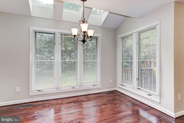 unfurnished dining area featuring plenty of natural light, dark hardwood / wood-style floors, and an inviting chandelier