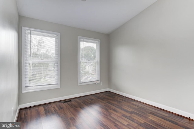 unfurnished room with dark hardwood / wood-style floors and vaulted ceiling