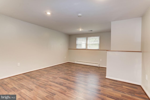 unfurnished room with dark hardwood / wood-style flooring and a baseboard radiator