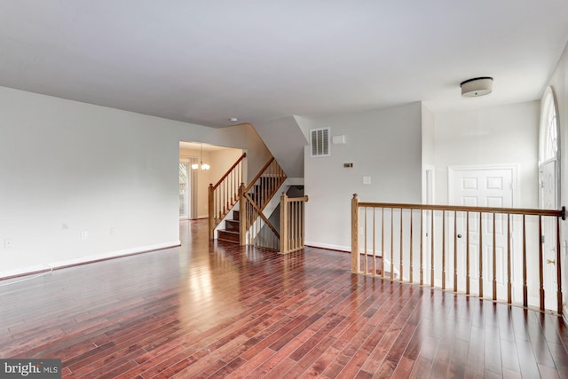 unfurnished room featuring a chandelier and hardwood / wood-style flooring