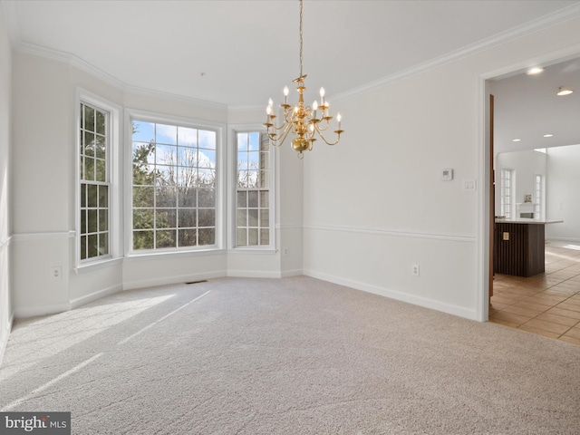 unfurnished dining area featuring carpet floors, ornamental molding, and an inviting chandelier