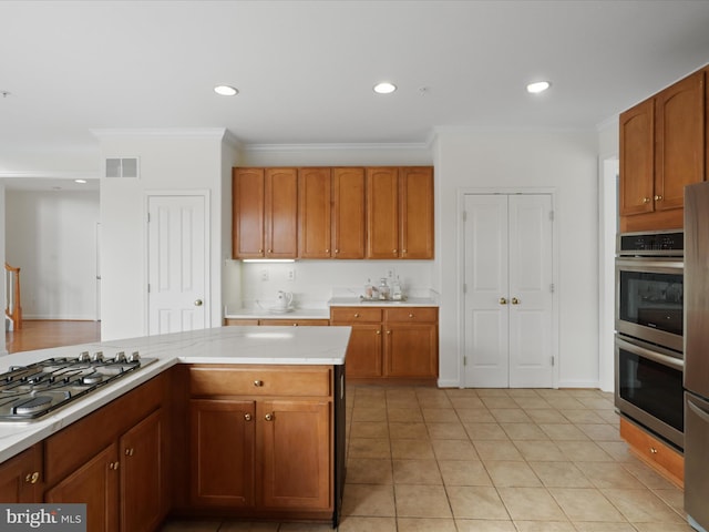 kitchen with appliances with stainless steel finishes, light tile patterned flooring, and crown molding