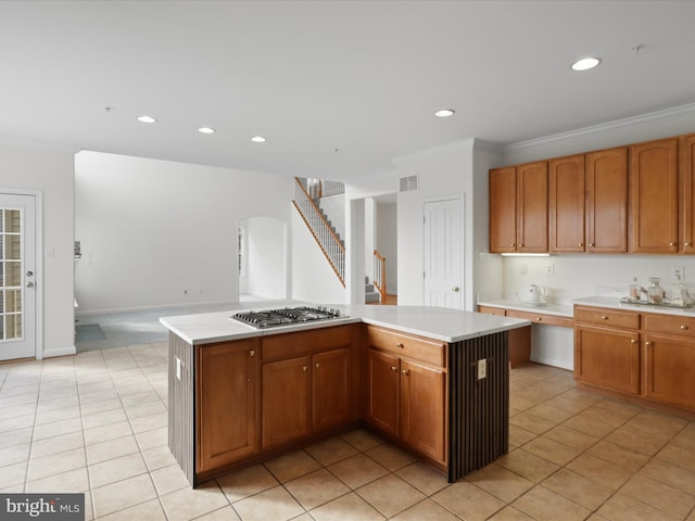 kitchen with a kitchen island, stainless steel gas cooktop, and crown molding