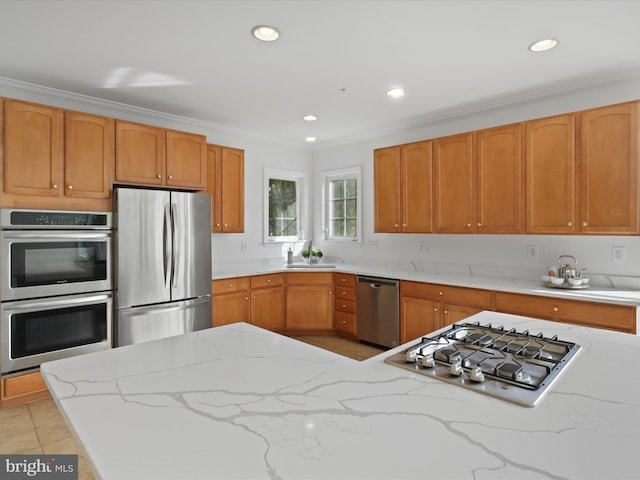 kitchen featuring sink, light stone counters, ornamental molding, light tile patterned floors, and appliances with stainless steel finishes