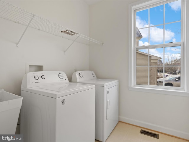 clothes washing area featuring separate washer and dryer and sink