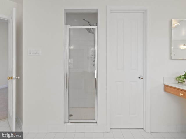 bathroom with an enclosed shower and tile patterned floors