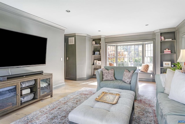 living room with ornamental molding and light hardwood / wood-style flooring