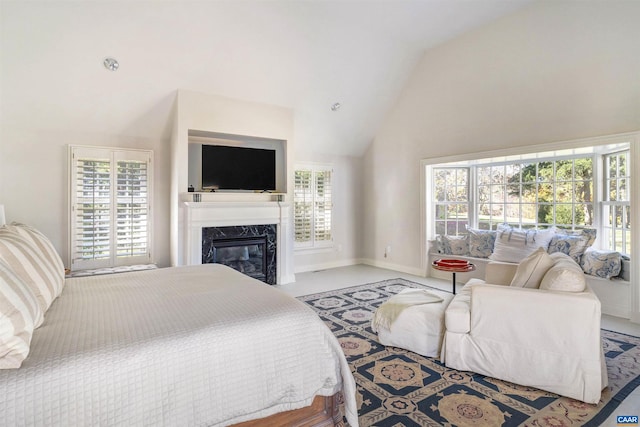 bedroom with vaulted ceiling and a premium fireplace