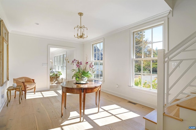 interior space with an inviting chandelier, crown molding, and light hardwood / wood-style floors