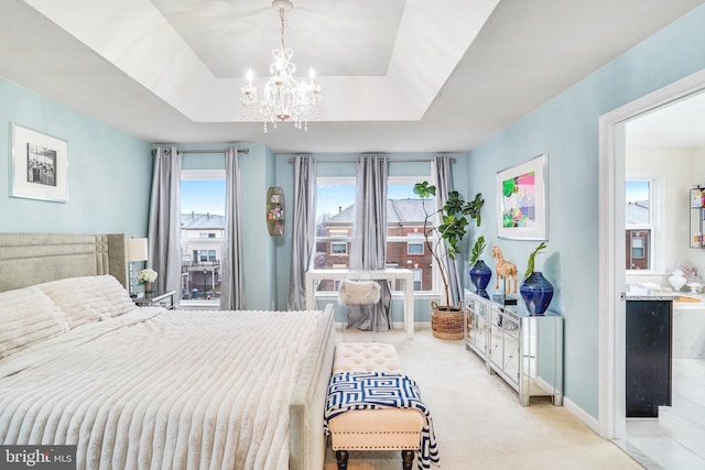 bedroom featuring baseboards, a tray ceiling, a chandelier, and light colored carpet