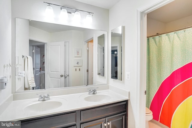 full bath with a shower with curtain, a sink, toilet, and double vanity