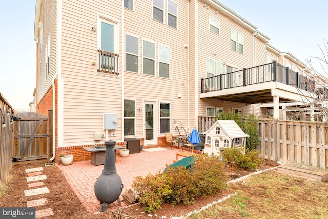 rear view of house featuring a gate, a patio, and fence