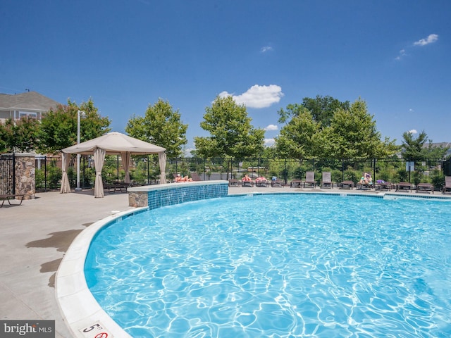 community pool featuring fence and a gazebo