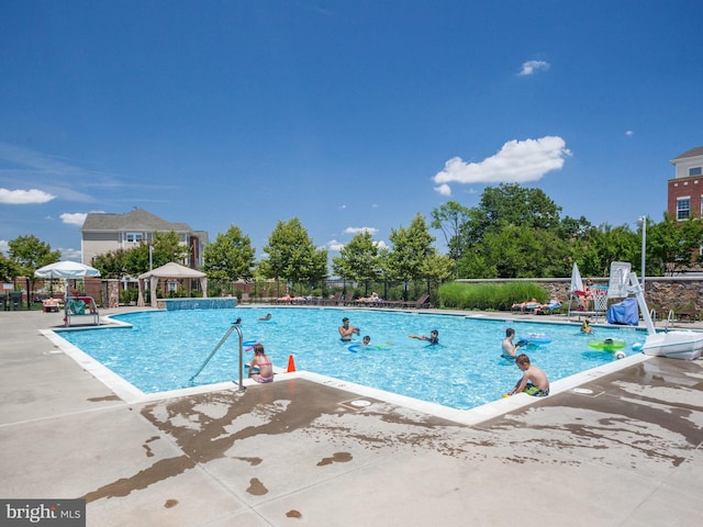 community pool featuring fence and a patio