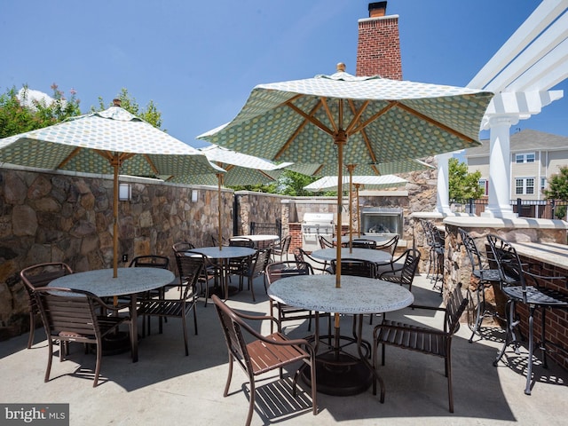 view of patio / terrace featuring a pergola, an outdoor bar, and area for grilling