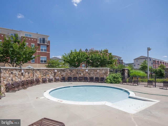 community pool featuring a patio area and fence