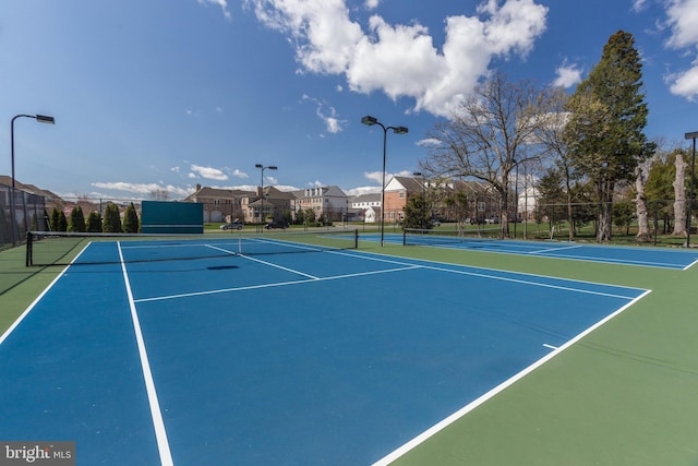 view of sport court with community basketball court, fence, and a residential view