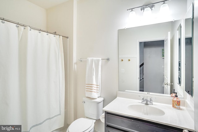 full bath with a shower with curtain, vanity, and toilet