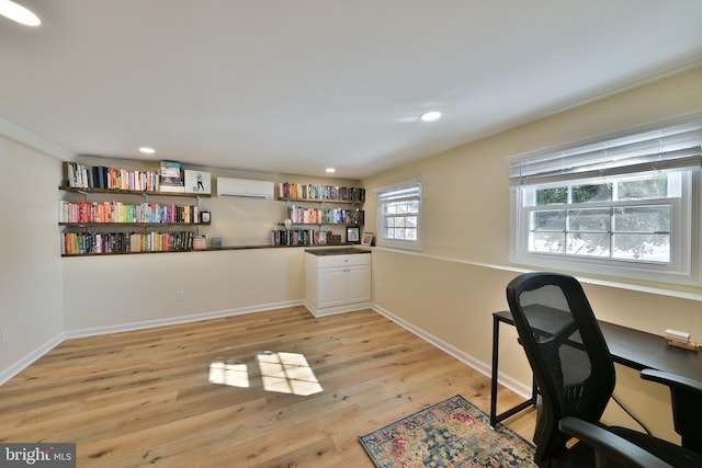 office space featuring light hardwood / wood-style floors and an AC wall unit