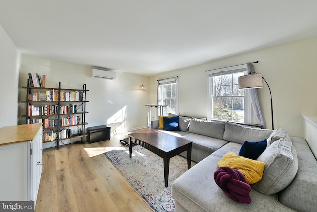 living room with light hardwood / wood-style floors and an AC wall unit