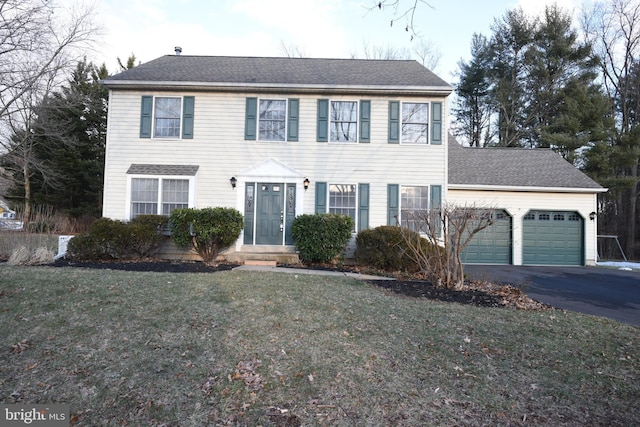 colonial home featuring a garage and a front yard