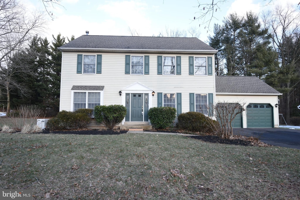 colonial-style house with a front lawn and a garage